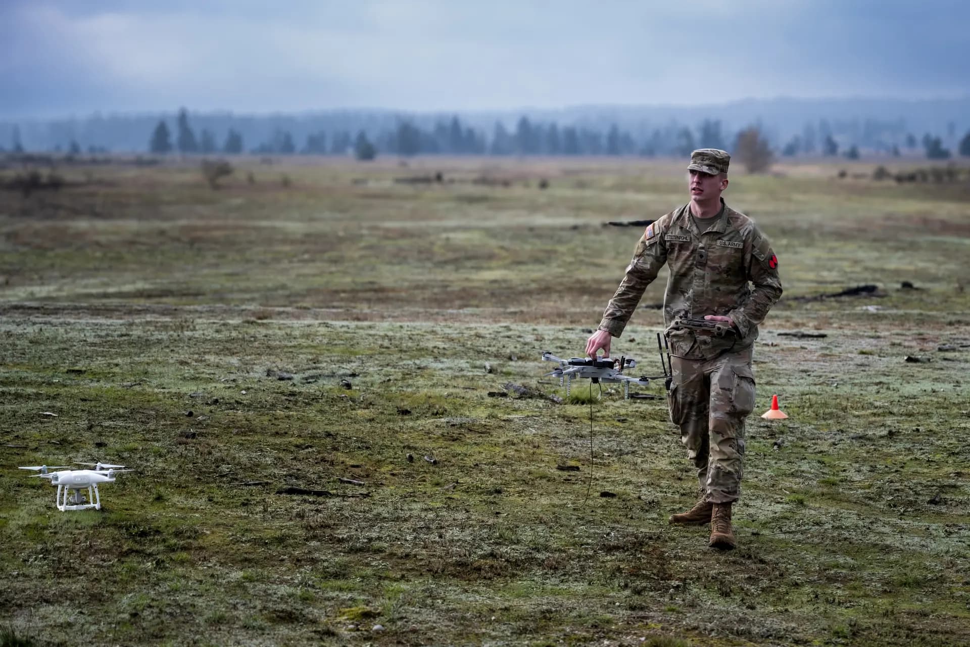 Soldier operating drone in open field