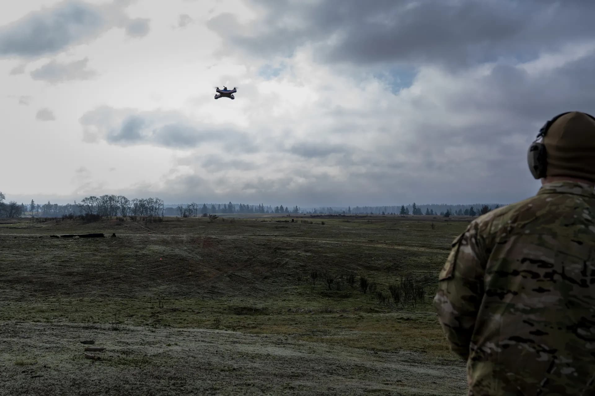 Soldier watching drone under overcast sky